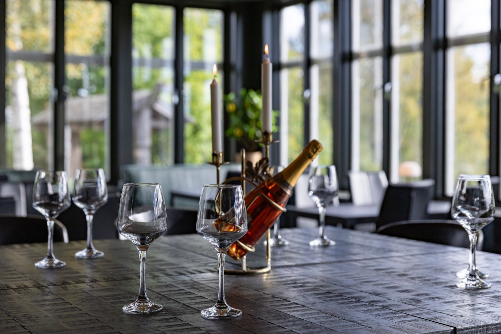 Gedeckter Tisch mit Gläsern und Kerzen im Speisesaal