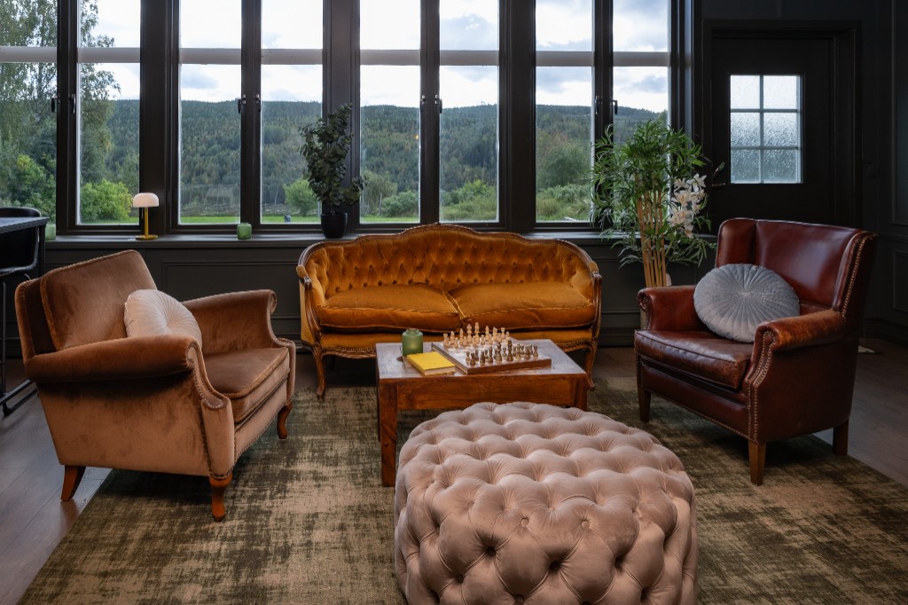 Lounge mit Waldblick durch große Fenster