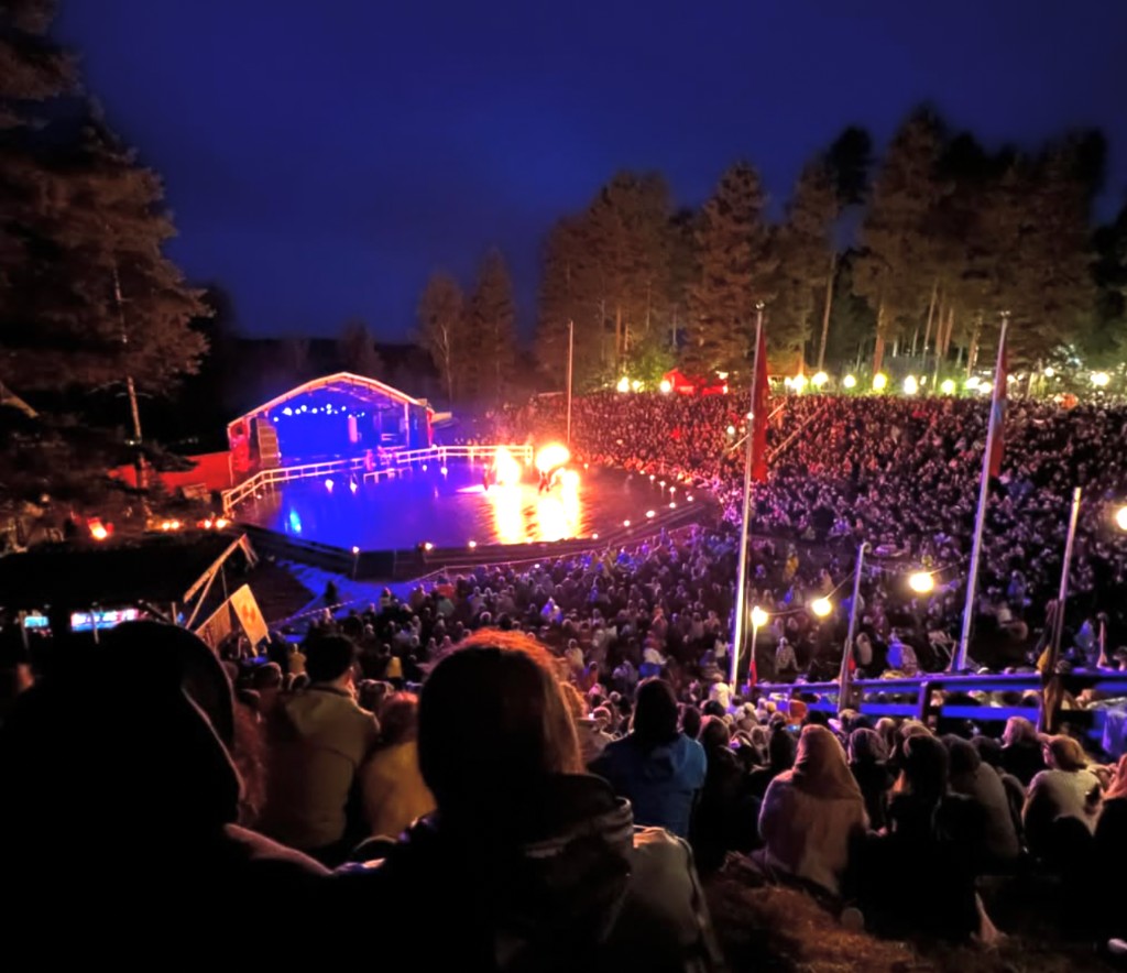 Publikum beim Urkult-Festival in Näsåker mit Feuershow und blau beleuchteter Bühne